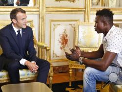 French President Emmanuel Macron, left, meets with Mamoudou Gassama, 22, from Mali, at the presidential Elysee Palace in Paris, Monday, May, 28, 2018. Mamoudou Gassama living illegally in France is being honored by Macron for scaling an apartment building over the weekend to save a 4-year-old child dangling from a fifth-floor balcony. (AP Photo/Thibault Camus, Pool)