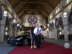 In a May 23, 2018 photo, Kimberly Phillips and Mike Fanto, co-owners of the Holy Grail Auto Garage in East Pittsburgh, pose for a portrait. The new auto storage facility is in the former St. Helen Catholic church. (Nate Guidry/Pittsburgh Post-Gazette via AP)
