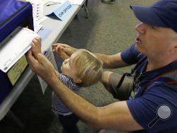 Christopher PapouchiIs gets help casting his ballot from his son, Nicholas, 2, Tuesday, June 5, 2018, in Sacramento, Calif. Voters are casting ballots in California's primary election, setting the stage for November races. (AP Photo/Rich Pedroncelli)