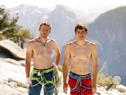 In this June 3, 2018 photo provided by Corey Rich, Alex Honnold, right, and Tommy Caldwell pose for a portrait at the top of El Capitan in Yosemite National Park, Calif. Days after two of the world's most celebrated rock climbers twice set astonishingly fast records on the biggest wall in Yosemite National Park, they did it again Wednesday, June 6, 2018, breaking a mark compared with track's four-minute mile. (Corey Rich/Reel Rock /Novus Select via AP)