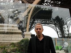 Architect Dietmar Feichtinger poses in front of a new security bulletproof glass barrier under construction around the Eiffel Tower in Paris, France, Thursday, June 14, 2018. Paris authorities have started replacing the metal security fencing around the Eiffel Tower with a more visually appealing glass wall. The company operating the monument said see-through panels are being set up instead of the fences at the north and south of the famed monument that