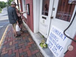 Passersby examine the menu at the Red Hen Restaurant Saturday, June 23, 2018, in Lexington, Va. White House press secretary Sarah Huckabee Sanders said Saturday in a tweet that she was booted from the Virginia restaurant because she works for President Donald Trump. Sanders said she was told by the owner of The Red Hen that she had to "leave because I work for @POTUS and I politely left." (AP Photo/Daniel Lin)