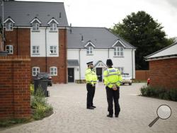 British police officers stand outside a residential property in Amesbury, England, Wednesday, July 4, 2018. British police have declared a "major incident" after two people were exposed to an unknown substance in the town, and are cordoning off various places the people are known to have visited in the area before falling ill. (AP Photo/Matt Dunham)