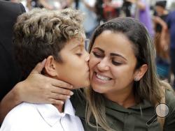 Diego Magalhaes, left, 10, kisses his mother Sirley Silveira, Paixao, an immigrant from Brazil seeking asylum with her son, after Diego was released from immigration detention, Thursday, July 5, 2018, in Chicago. (AP Photo/Charles Rex Arbogast)