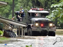 Firefighters from Wrightsville Fire Company use a five ton truck to evacuate residents from homes along flooded Drager Road in Columbia, Pa., Wednesday July 25, 2018. Days of drenching rains are closing roads, sending creeks and streams over their banks and causing businesses and to shut down in central Pennsylvania. (Blaine Shahan/LNP via AP)