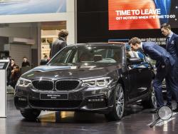FILE- In this Jan. 13, 2017, file photo men look at a BMW 5 series during the media day of the 95th European Motor Show in Brussels. The Insurance Institute for Highway Safety, in a paper titled “Reality Check,” issued the warning Tuesday, Aug. 7, 2018, after testing five of the systems from Tesla, Mercedes, BMW and Volvo on a track and public roads. The systems tested, in the Tesla Model 3 and Model S, BMW’s 5-Series, the Volvo S-90 and the Mercedes E-Class, are among the best in the business right now and