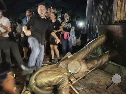 Protesters celebrate after the Confederate statue known as "Silent Sam" was toppled on the campus of the University of North Carolina in Chapel Hill, N.C., Monday, Aug. 20, 2018. (Julia Wall/The News & Observer via AP)