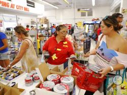City Mill hardware store sales associate Lisa Lavilla, left, talks to customer Ginger McCorriston about hurricane supplies, Wednesday, Aug. 22, 2018, in Honolulu. McCorriston was trying to find duck tape and batteries before they run out. Hurricane Lane has weakened as it approaches Hawaii but was still expected to pack a wallop, forecasters said Wednesday. (AP Photo/Marco Garcia)