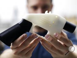 FILE - In this Aug. 1, 2018, file photo, Cody Wilson, with Defense Distributed, holds a 3D-printed gun called the Liberator at his shop in Austin, Texas. A federal judge in Seattle has granted an injunction that prohibits the Trump administration from allowing a Texas company to post 3D gun-making plans online. (AP Photo/Eric Gay, file)