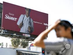 This May 9, 2018 photo shows a billboard for MedMen, a marijuana dispensary, at an intersection in Los Angeles. MedMen recently rolled out an ad campaign that featured photos of 17 people including a white-haired grandmother, a schoolteacher, a business executive, a former pro football player and a nurse, being splashed across billboards, buses and the web. (AP Photo/Chris Pizzello)