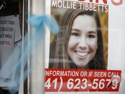 FILE - In this Aug. 21, 2018, file photo, a poster for missing University of Iowa student Mollie Tibbetts hangs in the window of a local business in Brooklyn, Iowa. Rob Tibbetts, father of slain Iowa college student Mollie Tibbetts in a Saturday, Sept. 1, opinion piece spoke out against using his daughter’s death “to advance views she believed were profoundly racist,” a call that comes after President Donald Trump and others seized on the suspected killer’s citizenship to argue for changes in U.S. immigrati