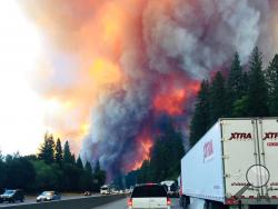 A fire rages as motorists travel on Interstate 5 near Lake Shasta, Calif., Wednesday, Sept. 5, 2018. (Jerri Tubbs via AP)