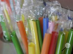 FILE - This July 17, 2018 file photo shows wrapped plastic straws at a bubble tea cafe in San Francisco. A law signed Thursday, Sept. 20, 2018, by Gov. Jerry Brown makes California the first state to bar full-service restaurants from automatically giving out single-use plastic straws. It takes effect next year. (AP Photo/Jeff Chiu, File)