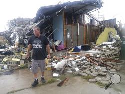 Brian Bon inspects damages in the Panama City downtown area after Hurricane Michael made landfall in Panama City, Fla., Wednesday, Oct. 10, 2018. Supercharged by abnormally warm waters in the Gulf of Mexico, Hurricane Michael slammed into the Florida Panhandle with terrifying winds of 155 mph Wednesday, splintering homes and submerging neighborhoods before continuing its march inland. (Pedro Portal/Miami Herald via AP)