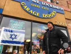 David Dvir stands in front of his business, Murray Avenue Locksmith, in the Squirrel Hill neighborhood of Pittsburgh, Monday, Oct. 29, 2018. Dvir, who was born in Israel but is an American citizen, voted for Donald Trump and doesn't agree with Jewish leaders who say the president shouldn't come to help mourn the victims of last week's synagogue massacre. (AP Photo/Allen G. Breed)
