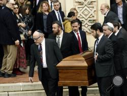 FILE - In this Oct. 30, 2018, file photo, a casket is carried out of Rodef Shalom Congregation after the funeral services for brothers Cecil and David Rosenthal, in Pittsburgh. The brothers were killed in the mass shooting last week at the Tree of Life synagogue. A team of rabbis and volunteers has gone into the Tree of Life synagogue to gather up blood and other remains from the victims of the shooting rampage, in keeping with Jewish law that says the entire body must be buried. (AP Photo/Matt Rourke, File