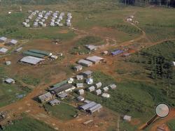 FILE - This November 1978 file photo shows the Peoples Temple compound, led by Jim Jones, after bodies were removed, in Jonestown, Guyana. Dozens of Peoples Temple members in Guyana survived the mass suicides and murders of more than 900 because they had slipped out of Jonestown or happened to be away Nov. 18, 1978. Those raised in the temple or who joined as teens lost the only life they knew. (AP Photo/File)