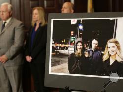 A picture of Katelyn McClure, right, Mark D'Amico, center, and Johnny Bobbitt Jr. is displayed during a news conference in Mt. Holly, N.J., Thursday, Nov. 15, 2018. Authorities say a New Jersey couple and a homeless man, Bobbitt Jr., made up a "feel good" story about the man helping them so they could raise money through an online fundraiser.(AP Photo/Seth Wenig)
