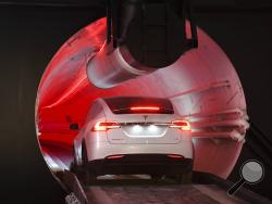 A modified Tesla Model X drives in the tunnel entrance before an unveiling event for the Boring Co. Hawthorne test tunnel in Hawthorne, Calif., Tuesday, Dec. 18, 2018. Elon Musk unveiled his underground transportation tunnel on Tuesday, allowing reporters and invited guests to take some of the first rides in the revolutionary albeit bumpy subterranean tube - the tech entrepreneur's answer to what he calls "soul-destroying traffic." (Robyn Beck/Pool Photo via AP)