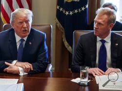 FILE - In this April 9, 2018, file photo, Deputy Secretary of Defense Patrick Shanahan, right, listen as President Donald Trump speaks during a cabinet meeting at the White House, in Washington. A U.S. administration official says that Defense Secretary Jim Mattis will leave his post Jan. 1, 2019, as Trump is expected to name Shanahan as acting secretary. (AP Photo/Evan Vucci, File)