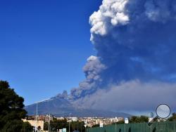 A smoke column comes out of the Etna volcano in Catania, Italy, Monday, Dec. 24, 2018. The Mount Etna observatory says lava and ash are spewing from a new fracture on the active Sicilian volcano amid an unusually high level of seismic activity. (Orietta Scardino/ANSA via AP)