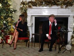 President Donald Trump and first lady Melania Trump each speak on the phone sharing updates to track Santa's movements from the North American Aerospace Defense Command (NORAD) Santa Tracker on Christmas Eve, Monday, Dec. 24, 2018. (AP Photo/Jacquelyn Martin)