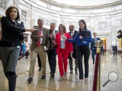 House Speaker Nancy Pelosi of Calif., center, speaks to reporters as she leaves an event with furloughed federal workers amid the partial government shutdown, Wednesday, Jan. 16, 2019, on Capitol Hill in Washington. (AP Photo/Andrew Harnik)