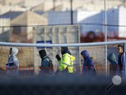 File-In this Dec. 13, 2018, file photo, teen migrants walk in line inside the Tornillo detention camp in Tornillo, Texas. Government investigators say many more migrant children may have been separated from their parents than the Trump administration has acknowledged. (AP Photo/Andres Leighton, File)