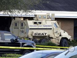 A Highlands County Sheriff's SWAT vehicle is stationed out in front of a SunTrust Bank branch, Wednesday, Jan. 23, 2019, in Sebring, Fla., where authorities say five people were shot and killed. (AP Photo/Chris O'Meara)