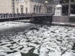 Pedestrians cross an icy Chicago River on Madison St. near the Civic Opera House in Chicago, Monday, Jan. 28, 2019. (Rich Hein/Chicago Sun-Times via AP)