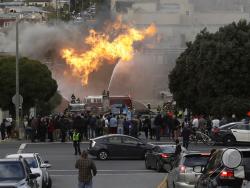 San Francisco firefighters battle a fire on Geary Boulevard in San Francisco, Wednesday, Feb. 6, 2019. A gas explosion in a San Francisco neighborhood shot flames high into the air Wednesday and was burning several buildings as utility crews scrambled to shut off the flow of gas. Construction workers cut a natural gas line, San Francisco Fire Chief Joanne Hayes-White said. (AP Photo/Jeff Chiu)