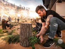In this Friday, Feb 15, 2019 photo, a worker puts some final touches on the diorama that is part of the Atlanta Cyclorama display at the Atlanta History Center on Friday, Feb 15, 2019, in Atlanta. The Atlanta Cyclorama depicts charging horses, wounded soldiers, cannon blasts and smoke as Union troops defeated Confederate forces and then torched much of the city.(AP Photo/ Ron Harris)
