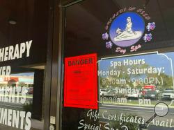 FILE - In this Feb. 19, 2019, file photo, a sign is posted outside of Orchids of Asia Day Spa in Jupiter, Fla., one of several spas closed in south Florida as a result of a six-month investigation into sex trafficking. The Florida prostitution sting that ensnared New England Patriots owner Robert Kraft is a reminder of the human trafficking and abuse taking place behind the darkened windows of many of these storefronts, and how challenging those problems can be to address. (Hannah Morse/Palm Beach Post via 