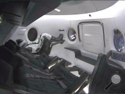 This photo provided by SpaceX shows a test dummy in the new Dragon capsule designed for astronauts. A six-day test flight will be real in every regard, beginning with a Florida liftoff Saturday, March 2, 2019 and a docking the next day with the International Space Station. The capsule won't carry humans, rather a test dummy, named Ripley after the tough heroine in the "Alien" films, in the same white SpaceX spacesuit that astronauts will wear. (SpaceX via AP)