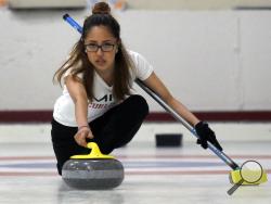 Kika Arias, of the Massachusetts Institute of Technology, delivers a rock during the college curling national championship, Friday, March 8, 2019, in Wayland, Mass. (AP Photo/Bill Sikes)