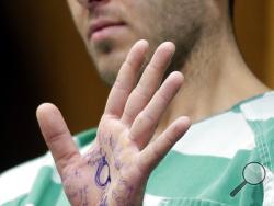 Anthony Comello displays writing on his hand that includes pro-Donald Trump slogans during his extradition hearing in Toms River, N.J., Monday, March 18, 2019. New York City police say a suspect is in custody in the shooting death of the reputed Gambino crime family boss. Chief of Detectives Dermot Shea says 24-year-old Comello was arrested Saturday, March 16, 2019, in the death of Francesco Cali on Wednesday in front of his Staten Island home. (AP Photo/Seth Wenig)
