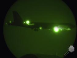 In this Thursday, May 9, 2019 photo released by the U.S. Air Force, a B-52H Stratofortress assigned to the 20th Expeditionary Bomb Squadron is seen through night vision coming in for a landing at Al Udeid Air Base, Qatar. The B-52 bombers ordered by the White House to deploy to the Persian Gulf to counter unspecified threats from Iran are beginning to arrive at a major American air base in Qatar. (Staff Sgt. Ashley Gardner/U.S. Air Force via AP)