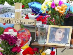 A memorial of flowers, balloons, a cross and photo of victim Marlen Ochoa-Lopez, are displayed on the lawn, Friday, May 17, 2019 in Chicago, outside the home where Ochoa-Lopez was murdered last month. Assistant State's Attorney James Murphy says a pregnant Ochoa-Lopez, who was killed and whose baby was cut from her womb, was strangled while being shown a photo album of the late son and brother of her attackers. (AP Photo/Teresa Crawford)