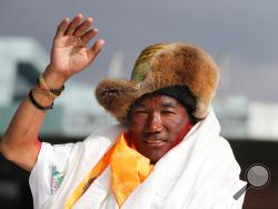 In this May 20, 2018, file photo, Nepalese veteran Sherpa guide, Kami Rita, 48, waves as he arrives in Kathmandu, Nepal. The Sherpa mountaineer extended his record for successful climbs of Mount Everest with his 24th ascent of the world's highest peak on Tuesday, May 21, 2019. (AP Photo/Niranjan Shrestha, File)