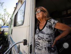 In this May 1, 2019, photo, Janelle Crosby stands in a donated recreational vehicle where she has lived with her husband since Hurricane Michael in Springfield, Fla. Crosby fears the beginning of hurricane season on June 1, and she said she isn't sure what would happen if another storm struck the hard-hit Florida Panhandle. (AP Photo/Jay Reeves)