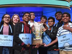 Co-champions of the 2019 Scripps National Spelling Bee, from left, Shruthika Padhy, 13, of Cherry Hill, N.J., Erin Howard, 14, of Huntsville, Ala., Rishik Gandhasri, 13, of San Jose, Calif., Christopher Serrao, 13, of Whitehouse Station, N.J., Saketh Sundar, 13, of Clarksville, Md., Sohum Sukhatankar, 13, of Dallas, Texas, Rohan Raja, 13, of Irving, Texas, and Abhijay Kodali, 12, of Flower Mound, Texas, hold the trophy in Oxon Hill, Md., Friday, May 31, 2019. (AP Photo/Susan Walsh)