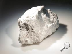 The "Genesis Rock," a 4.4 billion-year-old anorthosite sample approximately 2 inches in length, brought back by Apollo 15 and used to determine the moon was formed by a giant impact, is lit inside a pressurized nitrogen-filled examination case in the lunar lab at the NASA Johnson Space Center Monday, June 17, 2019, in Houston. (AP Photo/Michael Wyke)