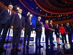 From left, New York City Mayor Bill de Blasio, Rep. Tim Ryan, D-Ohio, former Housing and Urban Development Secretary Julian Castro, Sen. Cory Booker, D-N.J., Sen. Elizabeth Warren, D-Mass., former Texas Rep. Beto O Rourke, Sen. Amy Klobuchar, D-Minn., Rep. Tulsi Gabbard, D-Hawaii, Washington Gov. Jay Inslee, and former Maryland Rep. John Delaney pose for a photo on stage before the start of a Democratic primary debate hosted by NBC News at the Adrienne Arsht Center for the Performing Arts, Wednesday, June 2