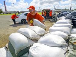 St. Bernard Parish Sheriff's Office inmate workers move free sandbags for residents in Chalmette, La., Thursday, July 11, 2019. The Mississippi Emergency Management Agency is telling people in the southern part of the state to be prepared for heavy rain from Tropical Storm Barry as it pushes northward through the Gulf of Mexico. (AP Photo/Matthew Hinton)