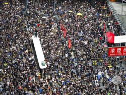 Protesters take part in a march on a street in Hong Kong, Sunday, July 21, 2019. Thousands of Hong Kong protesters marched from a public park to call for an independent investigation into police tactics. (AP Photo/Vincent Yu)
