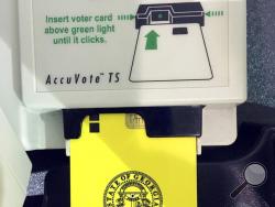 FILE - This May 22, 2018, file photo, shows a voter access card inserted in a reader during voting in the Georgia primary in Kennesaw, Ga. A federal judge has ordered Georgia to stop using its outdated voting machines after 2019. U.S. District Judge Amy Totenberg on Thursday, Aug. 15, 2019, issued the order after voting integrity advocates and individual voters asked her to order the state to immediately switch to hand-marked paper ballots. (AP Photo/Mike Stewart, File)