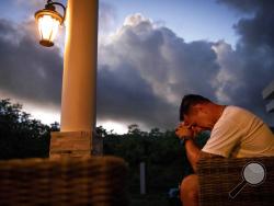 Walter Denton prays as the sun rises in his backyard in Agat, Guam, Saturday, May 11, 2019. Denton is one of over 200 former altar boys, students and Boy Scouts who are now suing Guam's Catholic archdiocese over decades of sexual abuse they say they suffered at the hands of almost three dozen clergy, teachers and scoutmasters. (AP Photo/David Goldman)