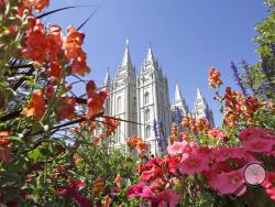 FILE - This Aug. 4, 2015 file photo, flowers bloom in front of the Salt Lake Temple, at Temple Square, in Salt Lake City. The Church of Jesus Christ of Latter-day Saints is reminding members that coffee is prohibited no matter how fancy the name, that vaping is banned despite the alluring flavors and that marijuana is outlawed unless prescribed by a competent doctor. (AP Photo/Rick Bowmer, File)