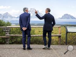 Federal Reserve Chairman Jerome Powell, left, and Bank of England Governor Mark Carney, right, pause in front of Mt. Moran after Powell's speech at the Jackson Hole Economic Policy Symposium on Friday, Aug. 23, 2019, in Jackson Hole, Wyo. (AP Photo/Amber Baesler)
