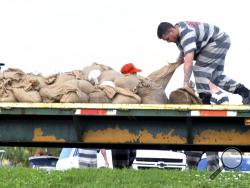 Brevard County prepares for the approach of Hurricane Dorian, as well over 100 vehicles lined up at 10:00am for free sandbags being filled by trustees from the Brevard County Jail in the parking lot of Calvary Chapel, a church in Viera West, it was one of several locations offering sandbags. (Tim Shortt/Florida Today via AP)